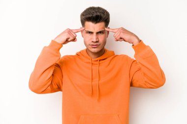 Beyaz arka planda izole edilmiş genç beyaz bir adam bir göreve odaklanmış, işaret parmaklarını işaret ediyor..