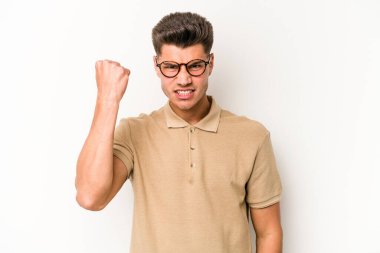 Beyaz arka planda izole edilmiş genç beyaz bir adam yumruğunu kameraya gösteriyor, agresif bir yüz ifadesi..