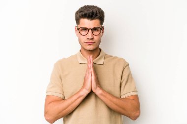 Beyaz arka planda izole edilmiş genç beyaz adam dua ediyor, bağlılık gösteriyor, dindar biri ilahi ilham arıyor..
