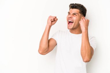 Beyaz arka planda izole edilmiş genç beyaz bir adam zaferden sonra yumruğunu kaldırıyor, kazanan konsept.