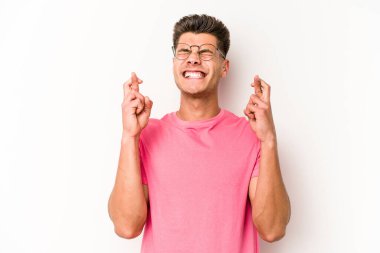 Beyaz arka planda izole genç beyaz adam şans dilemek için şans diliyor.