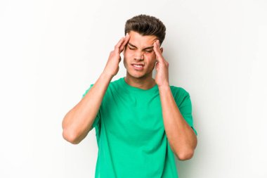 Beyaz arka planda izole edilmiş genç beyaz bir adam tapınaklara dokunuyor ve başı ağrıyor..