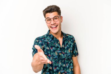 Beyaz arka planda izole edilmiş genç beyaz bir adam selamlama jesti olarak kameraya elini uzatıyor..