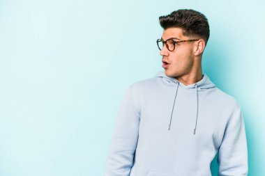 Kafkasyalı genç adam mavi arka planda izole edilmişti. Gördüğü bir şey yüzünden şok olmuştu..