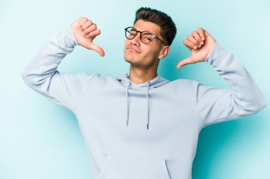 Mavi arka planda izole edilmiş genç beyaz adam gururlu ve kendinden emin hissediyor, örnek olarak.