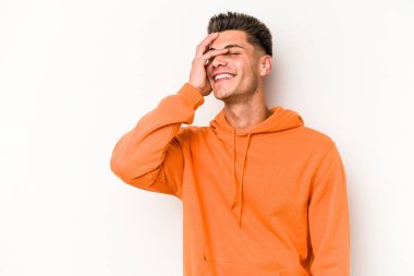 Beyaz arka planda izole olmuş genç beyaz bir adam gülüyor, kaygısız, doğal bir duygu..