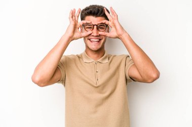 Beyaz arka planda izole edilmiş genç beyaz bir adam gözlerinde sorun olmadığını gösteriyor.