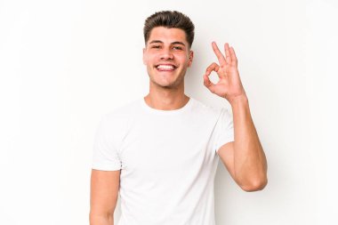 Beyaz arka planda izole edilmiş genç beyaz bir adam bir göz kırptı ve elleriyle iyi bir jest yaptı..