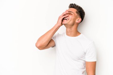 Beyaz arka planda izole olmuş genç beyaz bir adam gülüyor, kaygısız, doğal bir duygu..