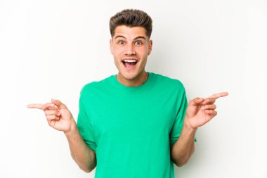 Beyaz arka planda izole edilmiş genç beyaz bir adam farklı kopya alanlarını gösteriyor, birini seçiyor, parmaklarıyla gösteriyor..