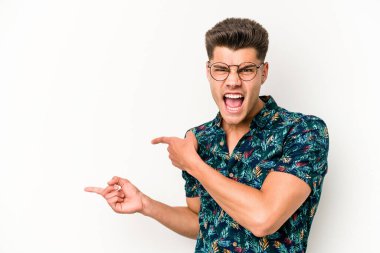 Beyaz arka planda izole edilmiş genç beyaz bir adam işaret parmağıyla fotokopi alanını işaret ederek heyecan ve arzusunu ifade ediyor..