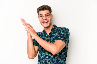 Beyaz arka planda izole olmuş genç beyaz bir adam enerjik ve rahat hissediyor, ellerini ovuşturuyor..