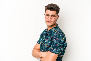 Beyaz arka planda izole edilmiş genç beyaz bir adam şüpheli, belirsiz, seni muayene ediyor..