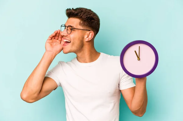 Joven Hombre Caucásico Sosteniendo Reloj Aislado Sobre Fondo Azul Gritando — Foto de Stock