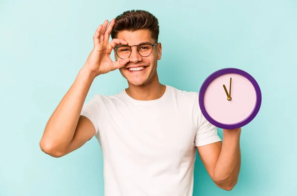 Young Caucasian Man Holding Clock Isolated Blue Background Excited Keeping — ストック写真