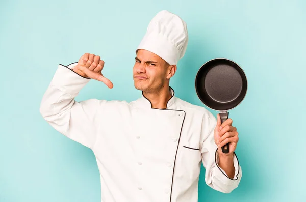 年轻的高加索厨师拿着被蓝色背景隔离的飞盘 感到自豪和自信 可以学习 — 图库照片