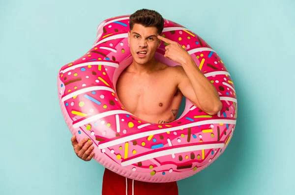 Young Caucasian Man Holding Inflatable Donut Isolated Blue Background Showing —  Fotos de Stock