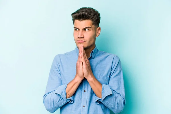 Jonge Blanke Man Geïsoleerd Blauwe Achtergrond Bidden Tonen Toewijding Religieuze — Stockfoto