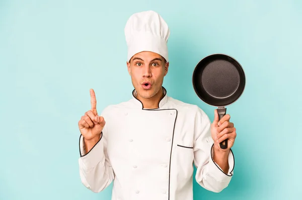 年轻的高加索厨师拿着被蓝色背景隔离的飞盘 有一些伟大的想法 创意的概念 — 图库照片