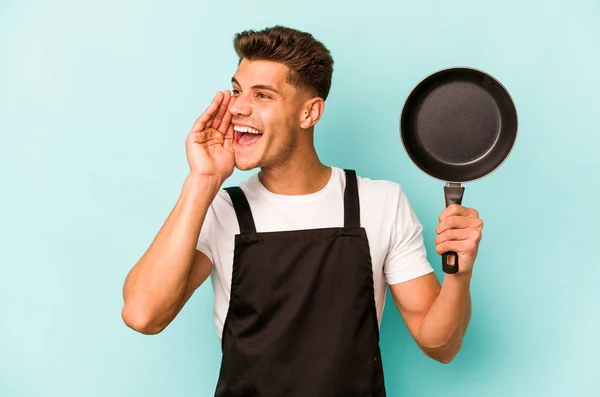 Young Caucasian Cooker Holding Frying Pan Isolated Blue Background Shouting — Foto Stock