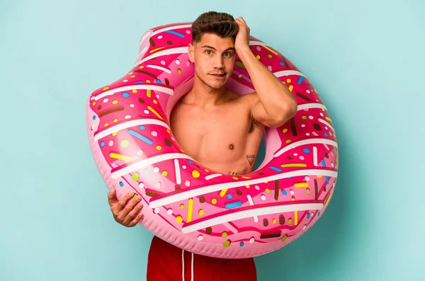 Young Caucasian Man Holding Inflatable Donut Isolated Blue Background Being —  Fotos de Stock