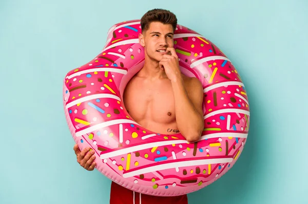 Young Caucasian Man Holding Inflatable Donut Isolated Blue Background Relaxed —  Fotos de Stock