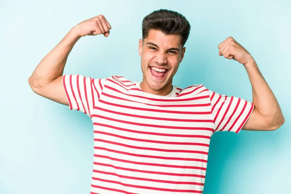 Joven Hombre Caucásico Aislado Sobre Fondo Azul Mostrando Gesto Fuerza —  Fotos de Stock