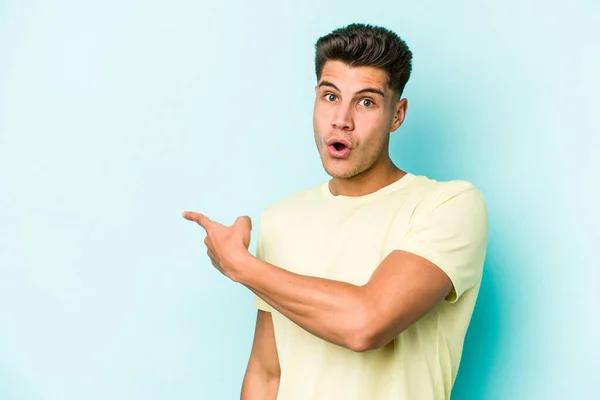 Jovem Caucasiano Isolado Fundo Azul Sorrindo Apontando Para Lado Mostrando — Fotografia de Stock