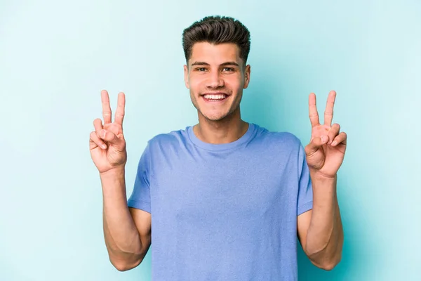 Jonge Blanke Man Geïsoleerd Blauwe Achtergrond Met Overwinningsteken Brede Glimlach — Stockfoto
