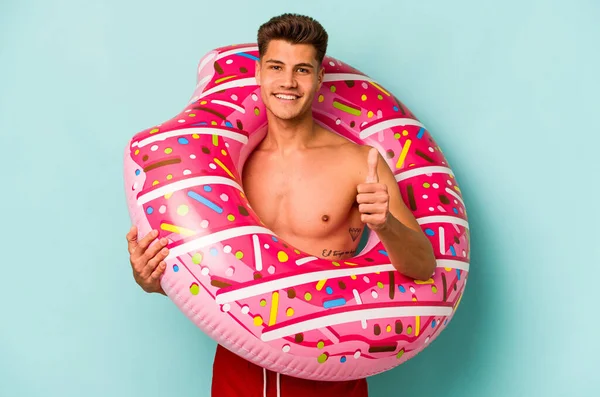 Young Caucasian Man Holding Inflatable Donut Isolated Blue Background Smiling —  Fotos de Stock