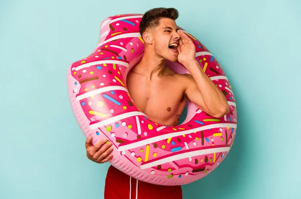 Young Caucasian Man Holding Inflatable Donut Isolated Blue Background Shouting —  Fotos de Stock