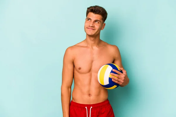 Young Caucasian Man Playing Volley Isolated Blue Background Dreaming Achieving — Stok fotoğraf