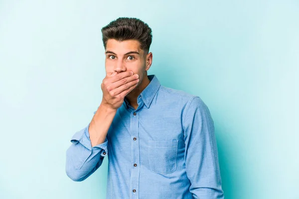 Ung Kaukasisk Man Isolerad Blå Bakgrund Täcker Munnen Med Händerna — Stockfoto