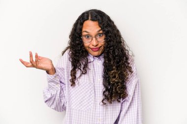 Beyaz arka planda izole edilmiş genç bir İspanyol kadın şüpheli bir tavırla omuz silkiyor..