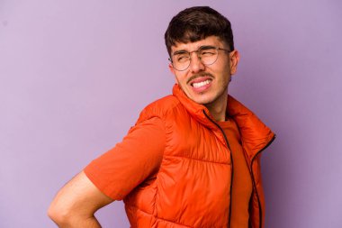 Mor arka planda izole edilmiş beyaz bir adam sırt ağrısı çekiyor..