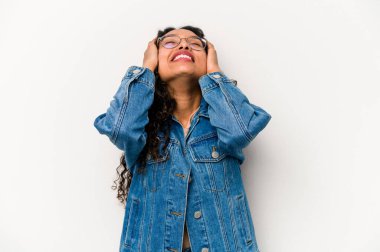 Beyaz arka planda izole edilmiş genç İspanyol kadın mutlu bir şekilde ellerini başının üstünde tutarak gülüyor. Mutluluk kavramı.