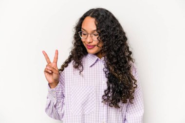 Beyaz arka planda izole edilmiş genç İspanyol kadın neşeli ve kaygısız parmakları olan bir barış sembolü gösteriyor..