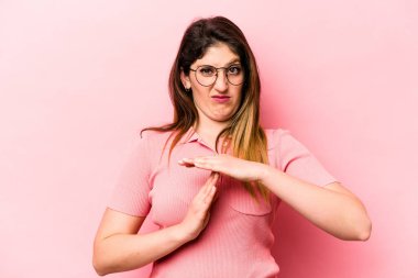 Pembe arka planda izole edilmiş genç beyaz kadın bir mola hareketi gösteriyor..