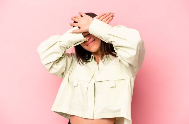 Pembe arka planda izole edilmiş genç İspanyol kadın iki kolu çapraz tutuyor, inkar kavramı.