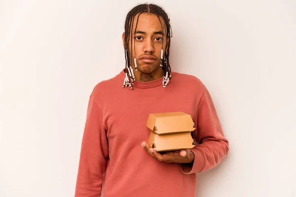 Jovem Afro Americano Segurando Hambúrguer Isolado Fundo Branco Encolhe Ombros — Fotografia de Stock