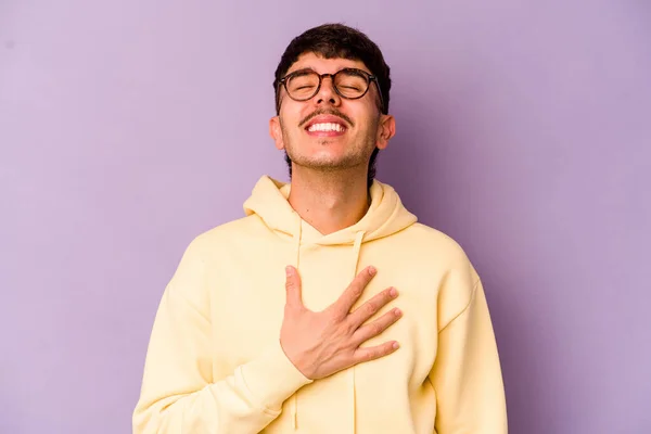 Jovem Caucasiano Isolado Fundo Roxo Voz Alta Mantendo Mão Peito — Fotografia de Stock