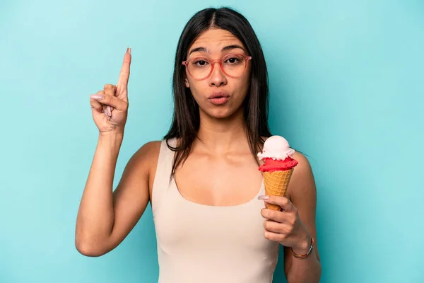 Jovem Hispânica Segurando Sorvete Isolado Fundo Azul Tendo Alguma Grande — Fotografia de Stock