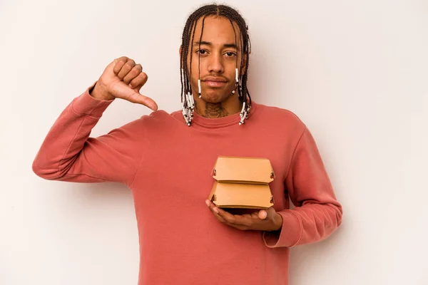 Młody Afroamerykanin Trzymając Hamburgera Białym Tle Czuje Się Dumny Pewny — Zdjęcie stockowe