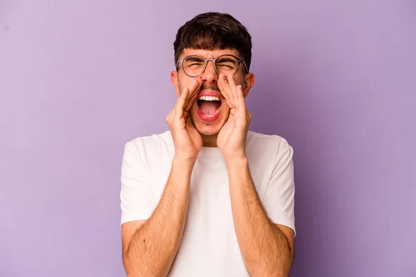 Young caucasian man isolated on purple background shouting excited to front.