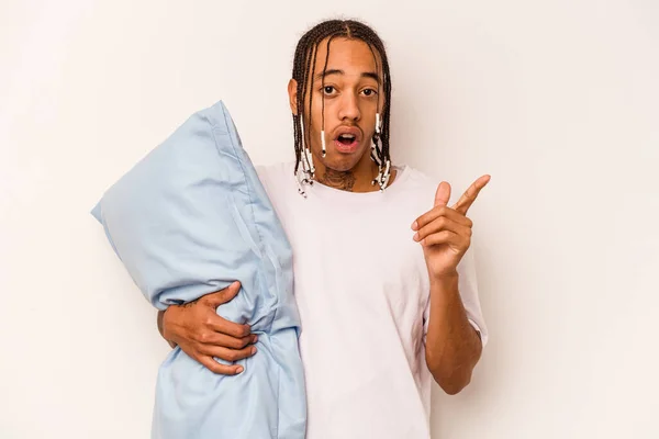 Young African American man wearing a pajama isolated on white background pointing to the side