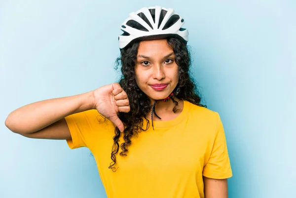 青い背景に隔離されたヘルメットバイクを身に着けている若いヒスパニックの女性は嫌いなジェスチャー 親指を示しています 意見の相違 — ストック写真
