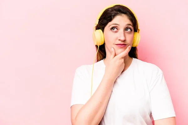 Νεαρή Καυκάσια Γυναίκα Που Ακούει Μουσική Απομονωμένη Ροζ Φόντο Κοιτώντας — Φωτογραφία Αρχείου