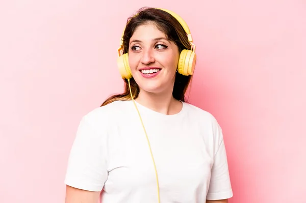 Young Caucasian Woman Listening Music Isolated Pink Background Looks Aside — Stock Photo, Image
