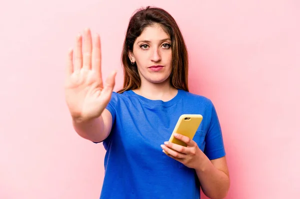 Ung Kaukasiska Kvinna Som Håller Mobiltelefon Isolerad Rosa Bakgrund Står — Stockfoto