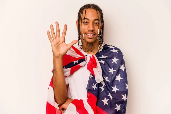 白い背景にアメリカ国旗を掲げた若いアフリカ系アメリカ人男性が笑顔で数字5と指を見せている — ストック写真